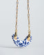 Gold paperclip chain necklace with hand-painted blue-and-white Talavera ceramic crescent pendant.