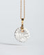 Gold chain necklace with hand‑painted gray‑and‑white Talavera ceramic disc pendant.