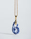 Gold chain necklace with hand‑painted blue‑and‑white Talavera ceramic teardrop pendant.