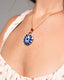 Gold chain necklace with hand‑painted blue‑and‑white Talavera ceramic disc pendant.