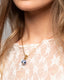 Gold chain necklace with hand‑painted blue‑and‑white Talavera ceramic bead pendant.