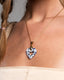 Gold chain necklace with hand‑painted blue‑and‑white Talavera open‑heart ceramic pendant.