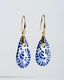 Gold hook earrings with blue-and-white Talavera ceramic teardrop drops.