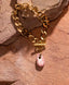 Gold toggle chain bracelet with hand‑painted pink Talavera teardrop charm.